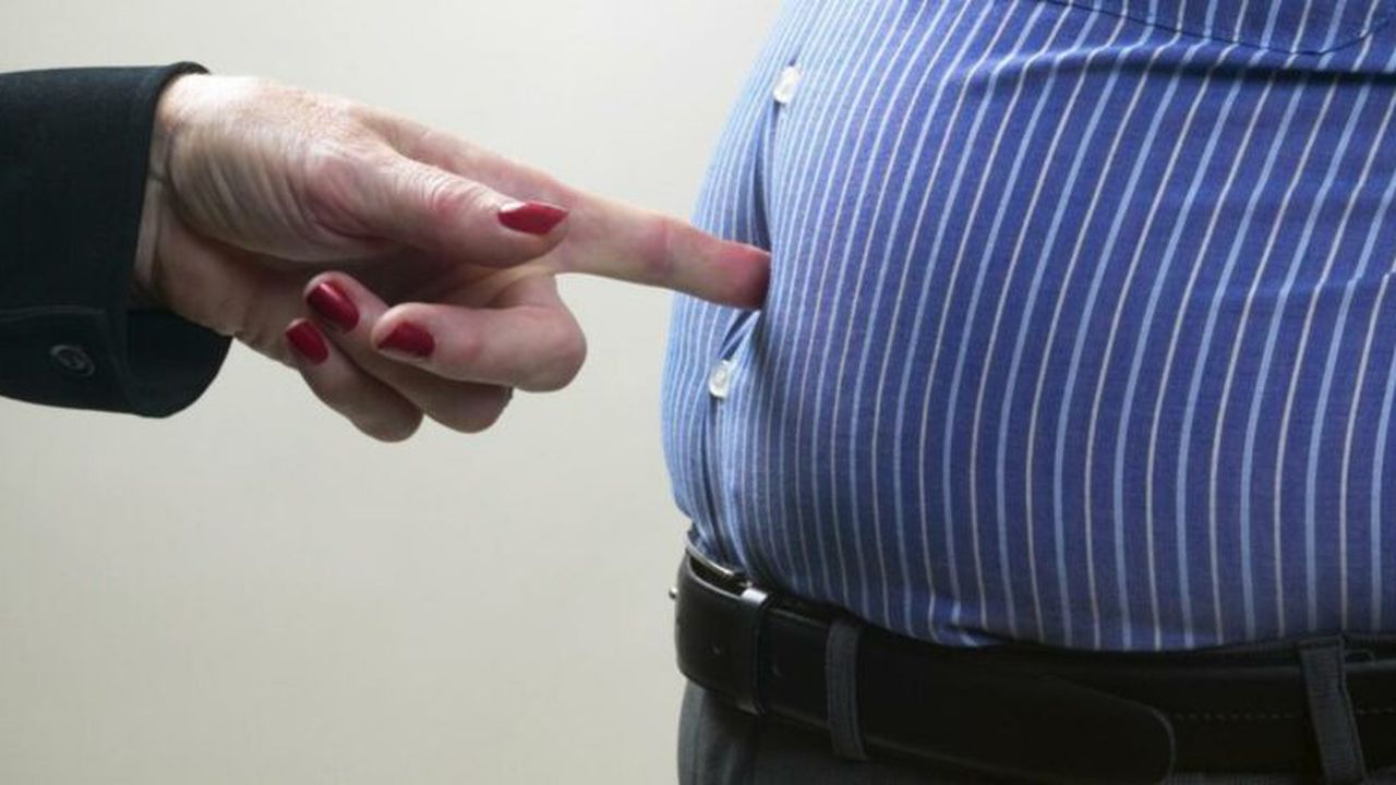 Woman poking man in stomach, mid section