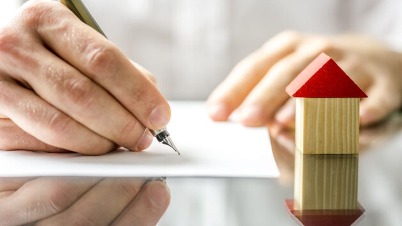 Man signing a contract when buying a new house