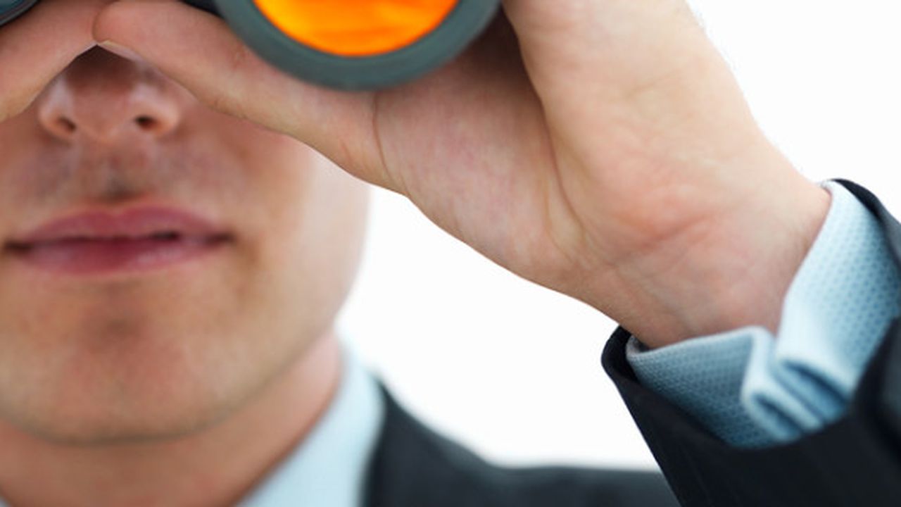 Young business man looking through binocular