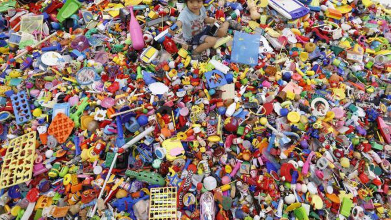 A boy plays on an artwork made of unwanted toys at the solo exhibition of Japanese artist Hiroshi Fuji, in Tokyo