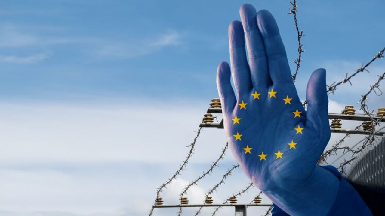 Hand,With,European,Flag,Stops,Immigration,Of,Refugees,,Blurred,Border