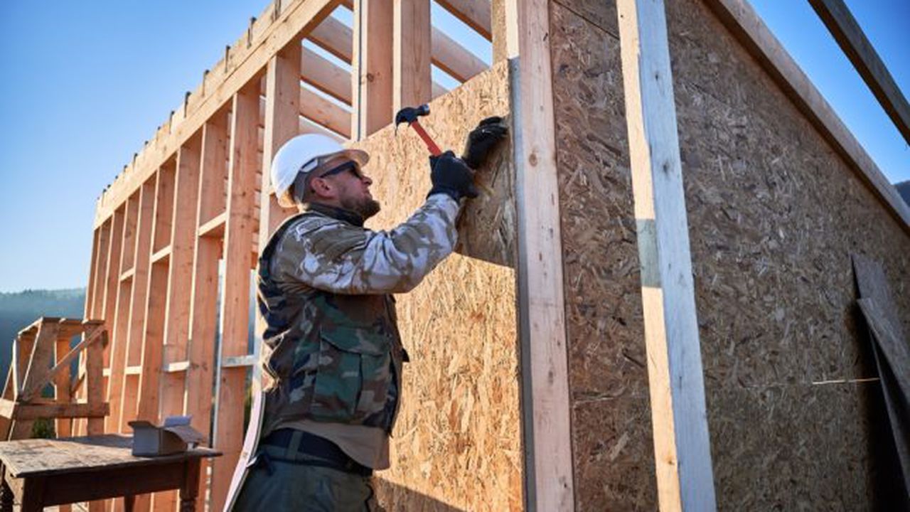 Carpenter,Hammering,Nail,Into,Osb,Panel,On,The,Wall,Of