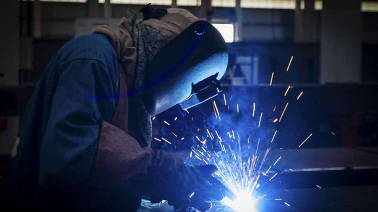 worker with protective mask welding metal