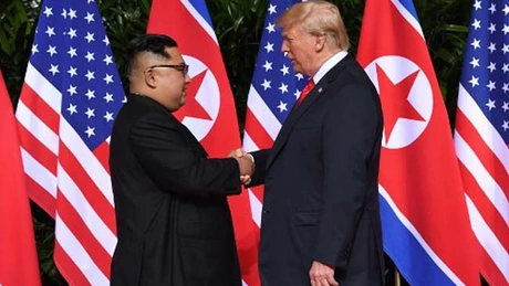 Trump şi Kim Jong Un îşi dau mâna. 